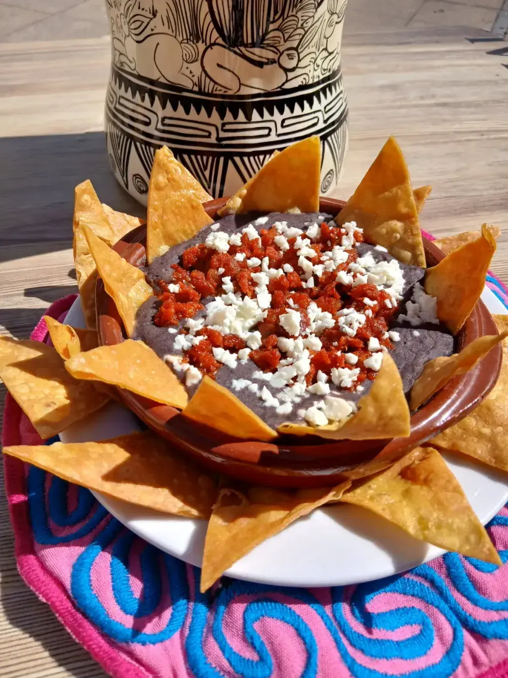 Frijolitos Refritos con Chorizo Los frijoles se consumen en México en gran diversidad de formas. Su variante mexicana más popular se caracteriza porque los frijoles se muelen mientras se fríen en aceite o manteca, después de haberse cocido hervidos, y sirven como guarnición de platillos populares acompañados con totopos o tortillas. Es común añadirles chorizo y queso saladito, así los servimos aquí acompañados de totopos.
