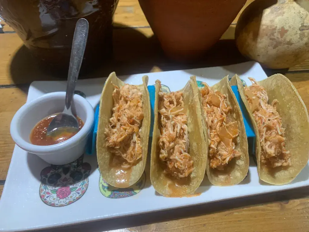 Tacos de Tinga de Pollo Pollo deshebrado en tinga casera, cocinado lentamente con tomate, cebolla y un punto ahumado de chipotle. Montado sobre tortillas de maíz calientes, con un equilibrio perfecto entre suavidad, aroma y un picante muy amable.